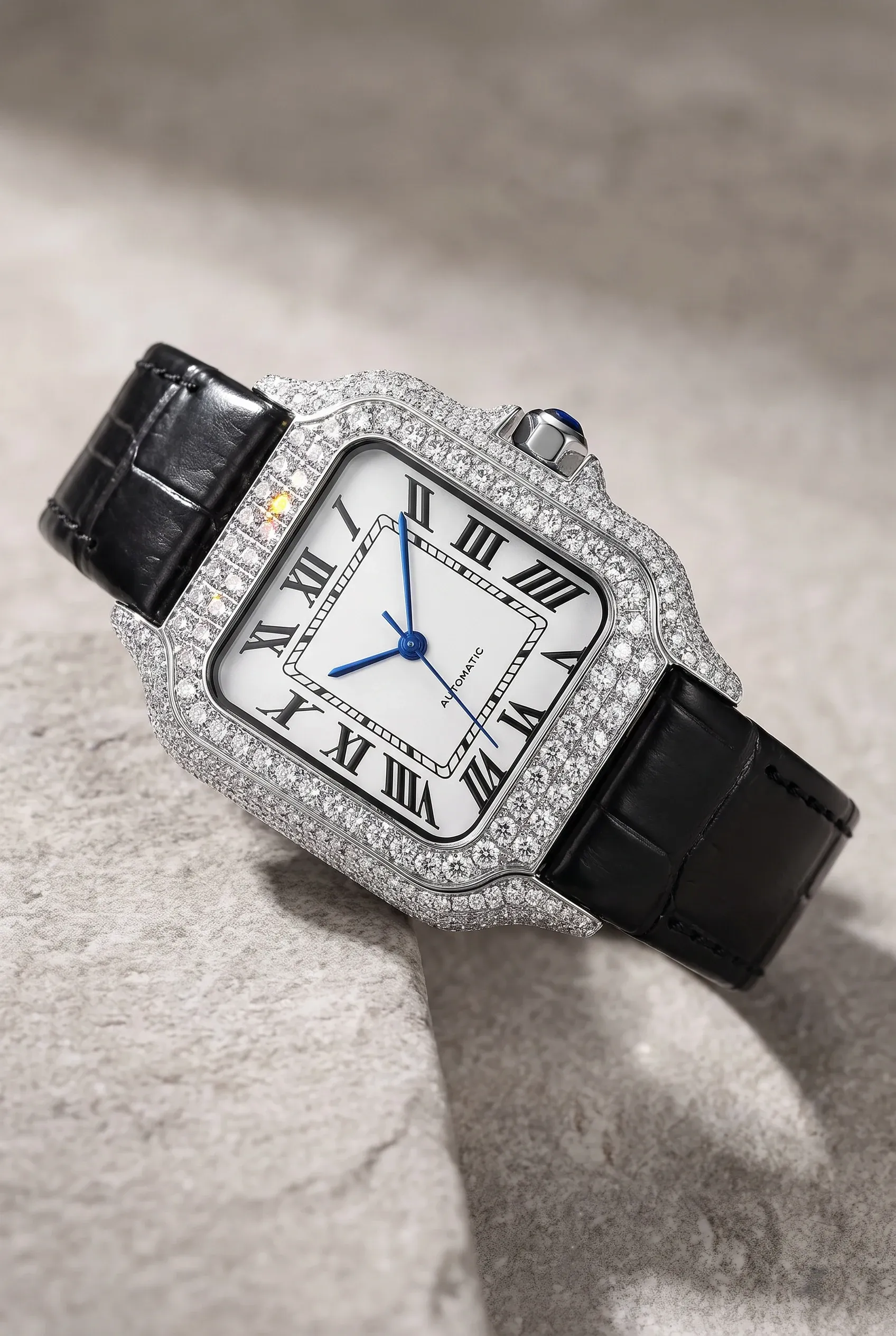 Close view of a square women’s moissanite watch with a leather strap on a neutral stone surface
