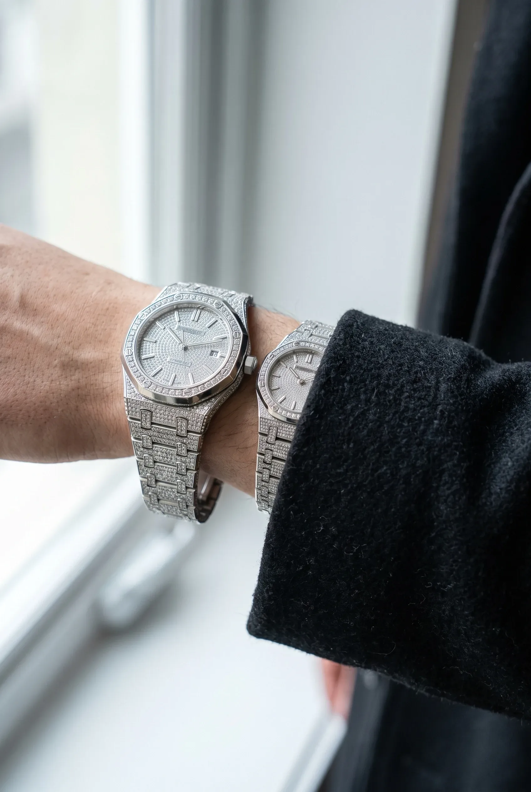 Two stone-set watches on wrists, one oversized and loose, the other fitted close to the wrist.
