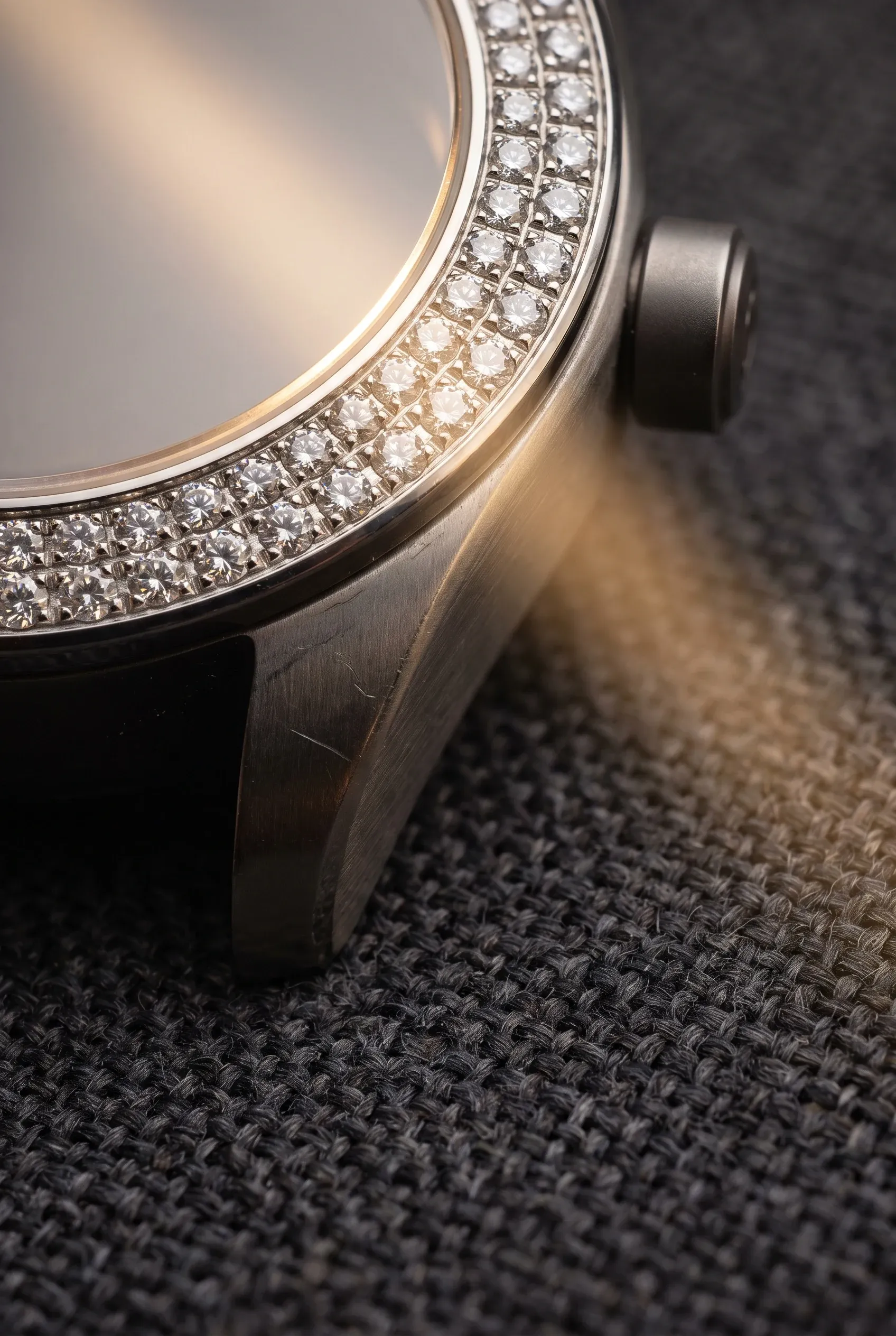 Macro contrast between moissanite-set watch details and plain brushed metal watch for a modern couple pairing.