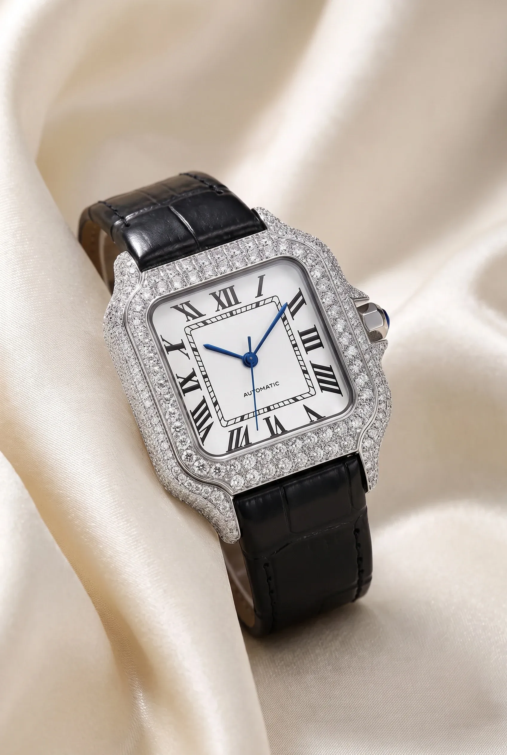 Small square stone-set women's watch on cream satin with a slim strap and compact case.