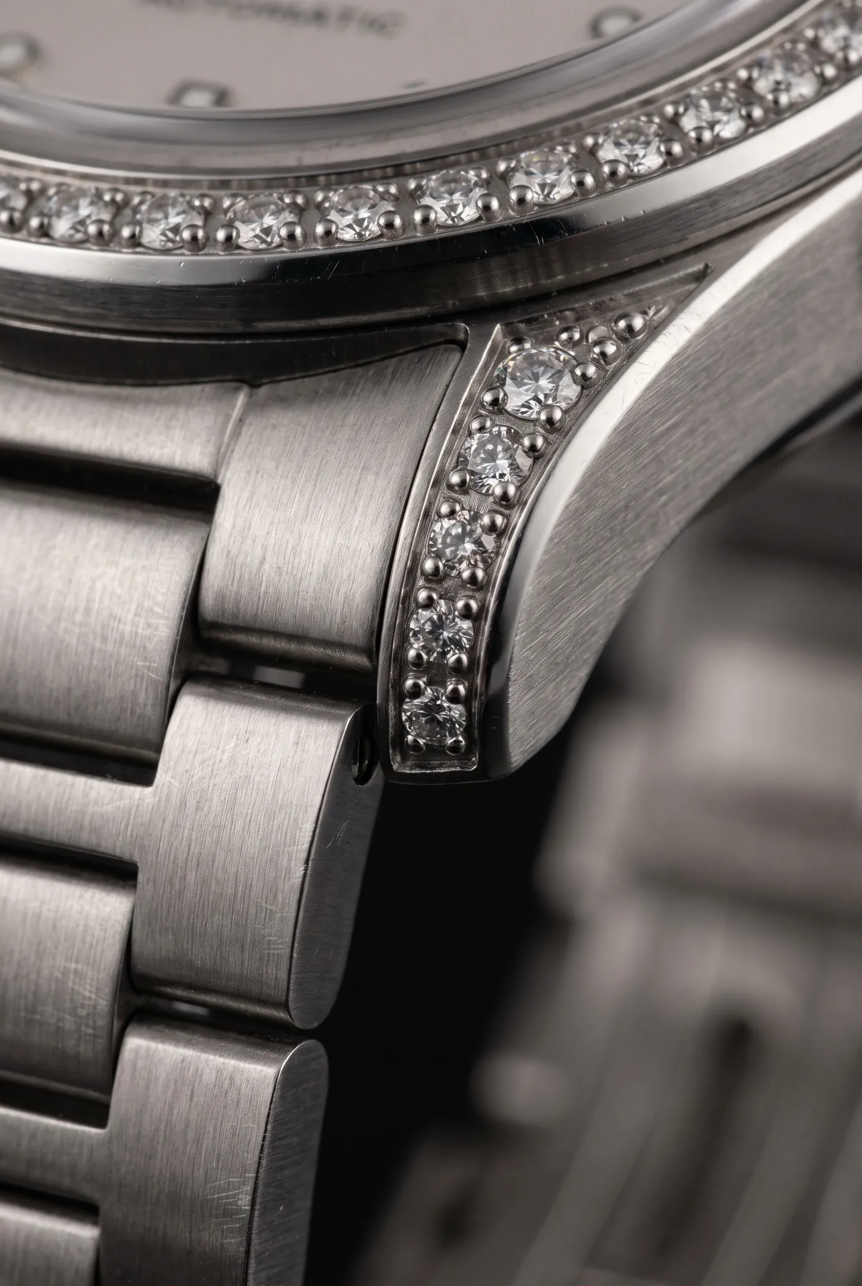 Macro view of prong-set stones on a watch bracelet and case, emphasizing setting quality and durability.