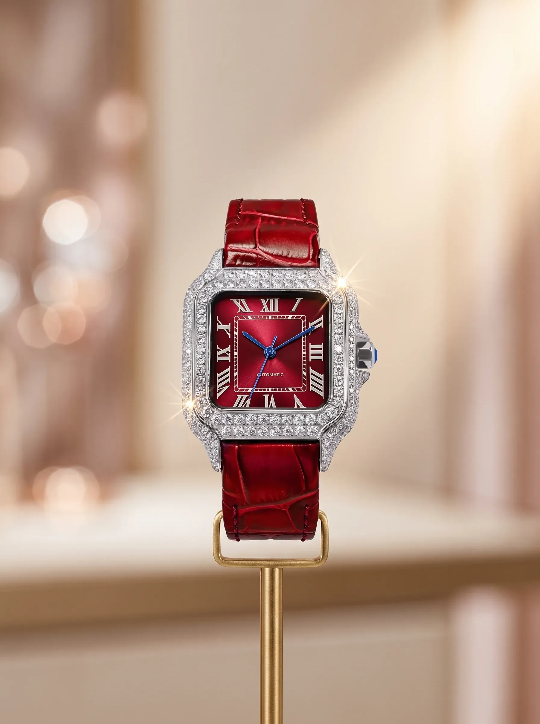 Moissanite-set watch with a red leather strap presented on a brass display stand in soft boutique light