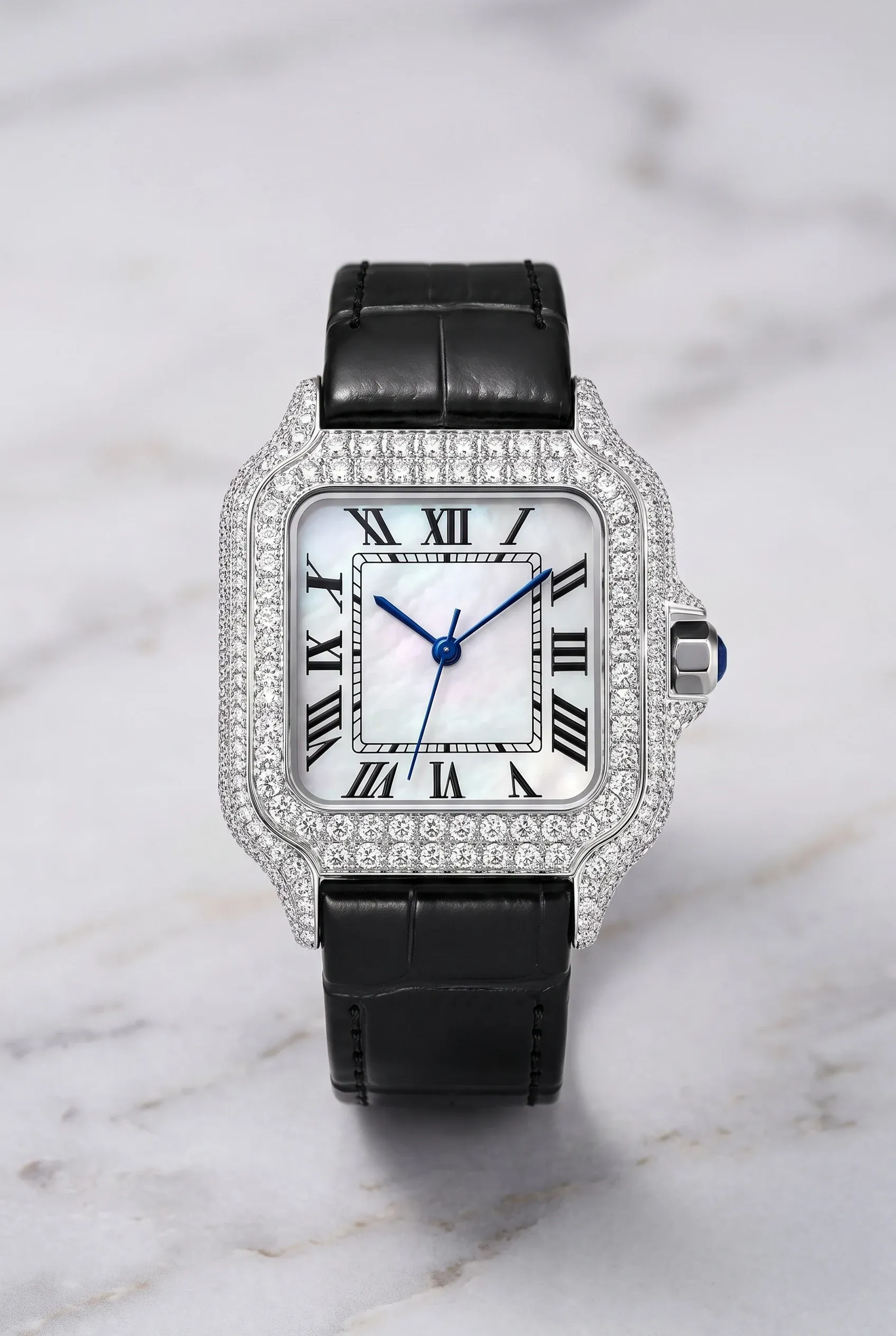 Square women’s watch with a mother-of-pearl dial, stone-set bezel, and leather strap on pale marble.