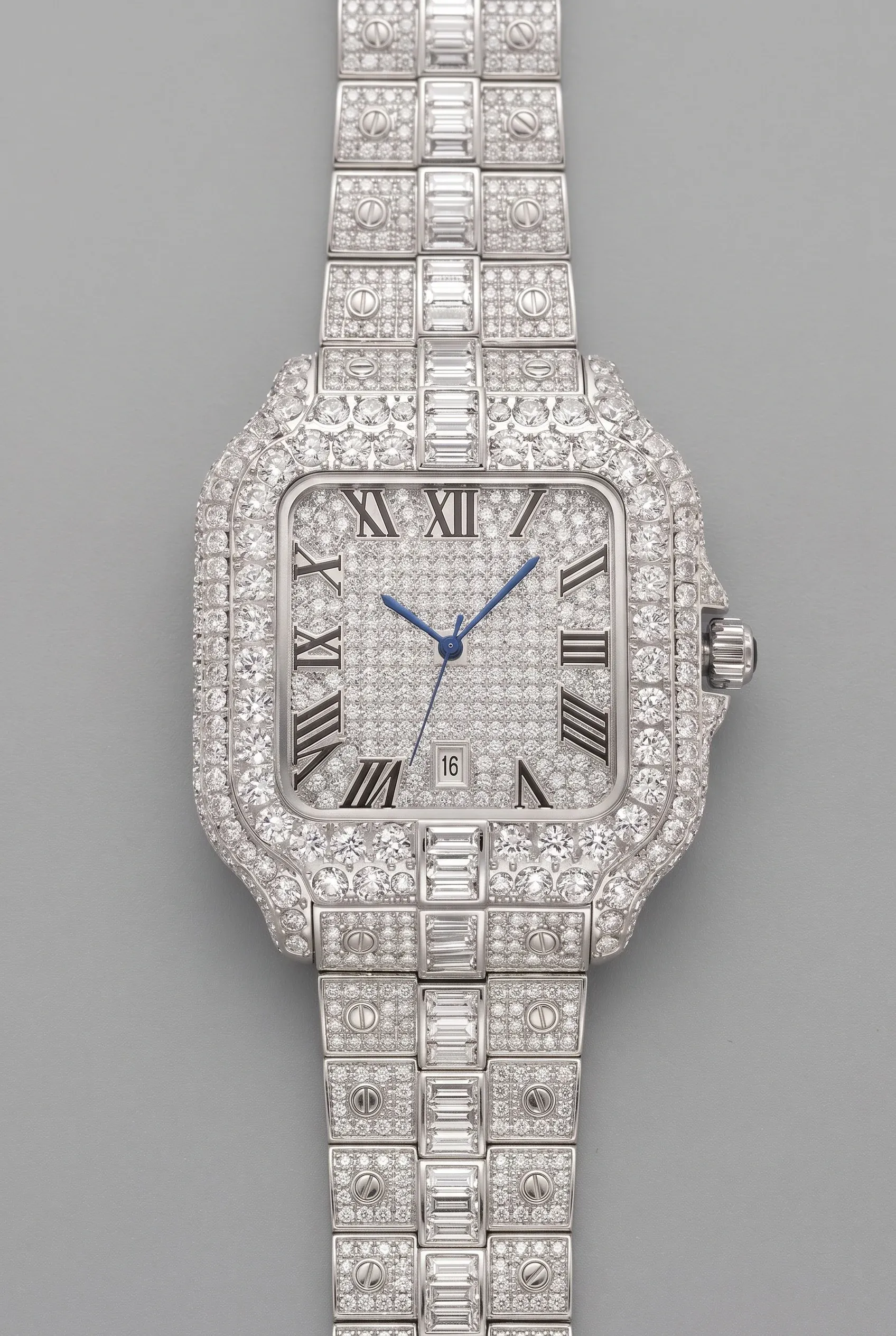 Fully stone-set silver tone watch with bright bezel, dial, and bracelet links on a clean gray surface